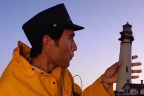 A screenshot from a Zach King TikTok showing him holding a tiny lighthouse