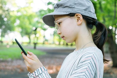 A girl uses her smartphone to measure silence.