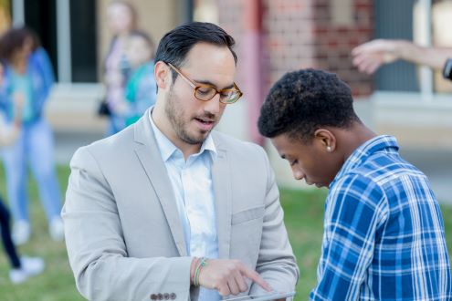 School principal helps student with iPad