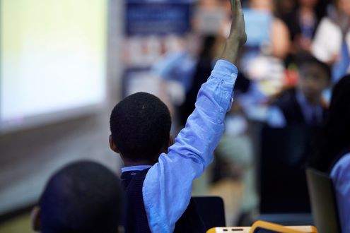 A student raises his hand in class.