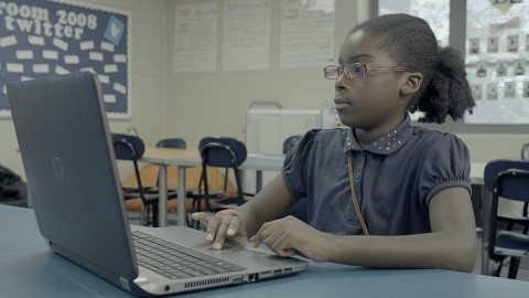 Un estudiante trabaja en una tarea de escritura en la computadora.