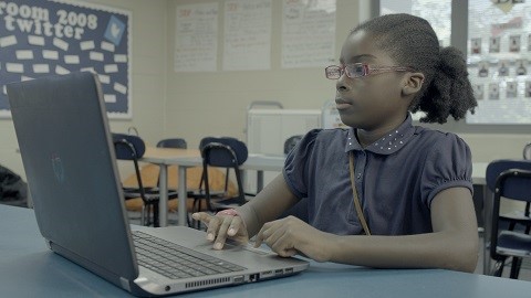 A student works on a writing assignment on the computer