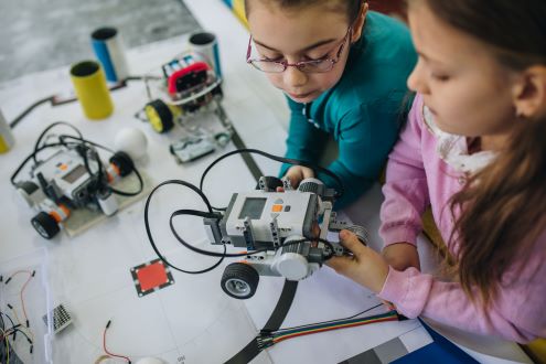 Two girls code a robotic vehicle