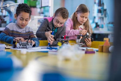 three children work in school makerspace