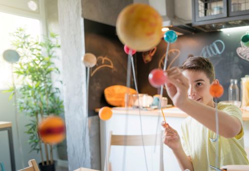 A student examines a solar system model