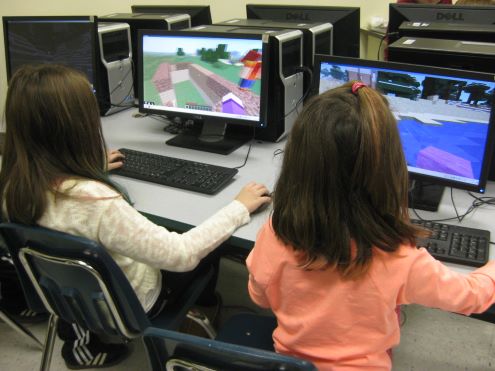 Two girls playing Minecraft in school