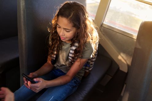 A girl uses wi-fi on a bus