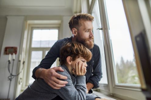 un padre consuela a su hijo durante la cuarentena COVID