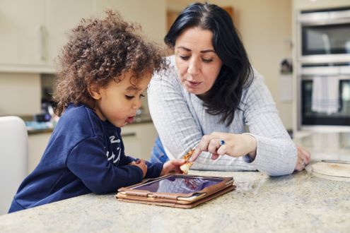 Un padre ayuda a un niño a usar un iPad