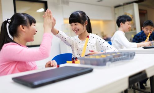 Two student celebrate with a high five