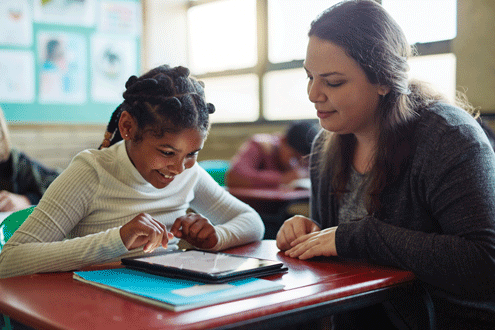 A teacher works with a student