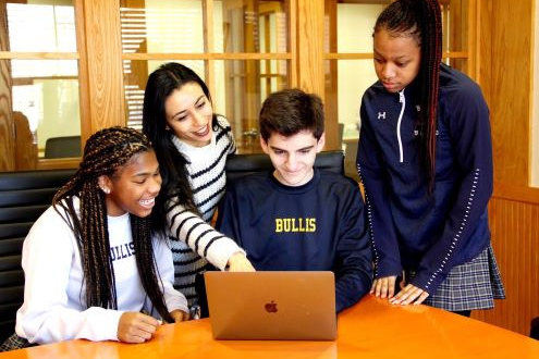Students look over a computer screen