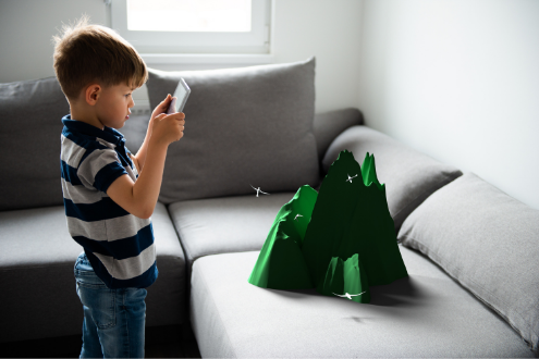A young boy uses an AR app to see a 3D image of a mountain