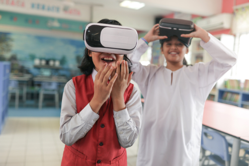 Two students in a classroom wearing VR head gear