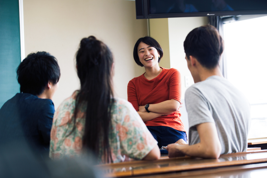 Un estudiante comparte una risa con otros tres estudiantes.