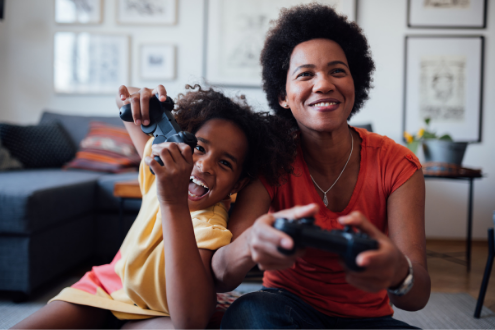 A girl plays a video game with her mom