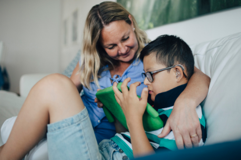 Una madre habla con su hijo mientras usa una tableta digital.