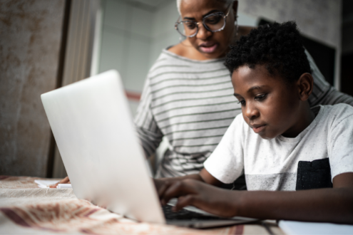 Un padre ayuda a su hija con el trabajo escolar en una computadora portátil