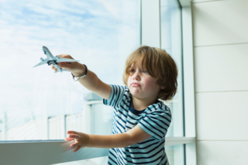 a boy plays with a toy plane at the airport