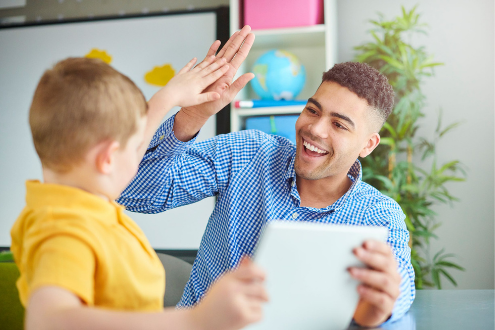 A teacher high fives a student