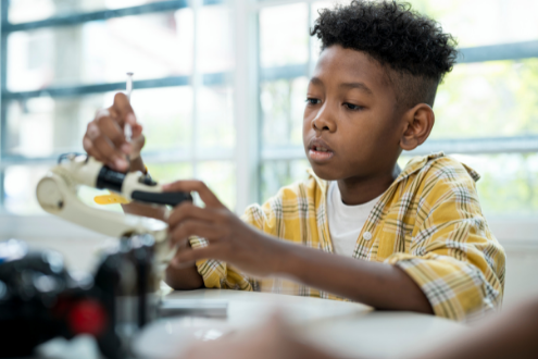 A boy works on a robotic vehicle