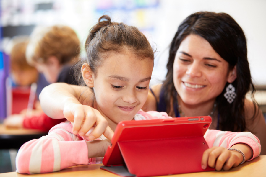 A teacher helps a student with the iPad