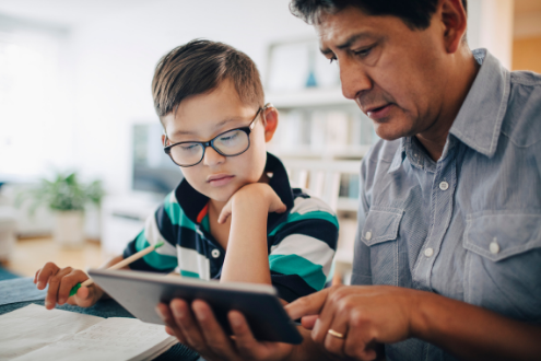 A boy and his dad do homework together at home