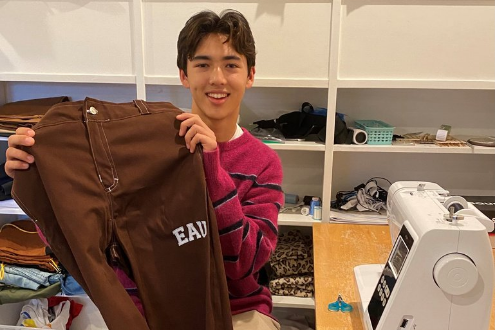 El estudiante de secundaria Ryman Yang sostiene un par de pantalones para la nieve que diseñó y fabricó.