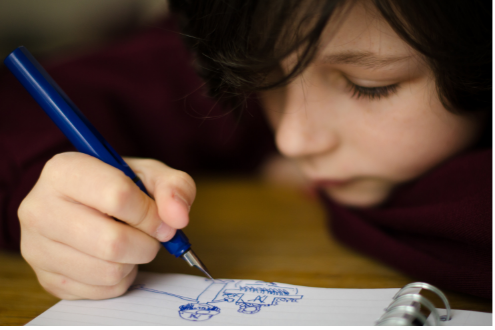 A student sketches in a notebook.