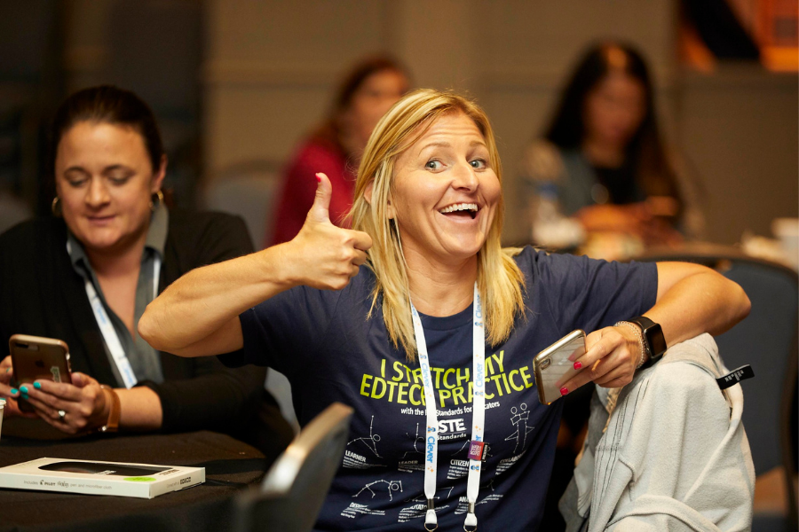 A women smiles while giving a thumbs up at ISTE19