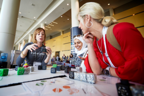 Two educators watch a demonstration of merge cubes at ISTELive