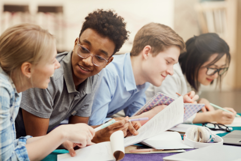 cuatro estudiantes trabajan codo con codo en un proyecto