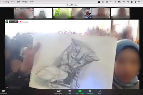 Una niña afgana, cuyo rostro está borroso, sostiene un dibujo de un gatito que ella creó ante la cámara mientras los rostros de estudiantes de todo el mundo aparecen en la parte superior de la pantalla de Zoom.