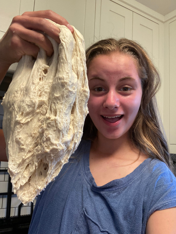 Audrey Snelling holds up a piece of bread dough