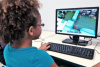 A girl plays Minecraft on a desktop
